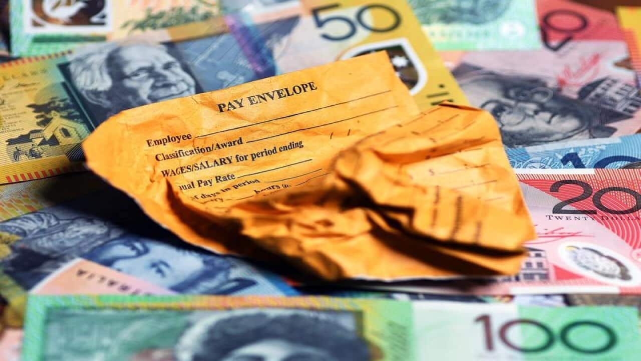 This is a file stock image of a pay envelope on top of money.