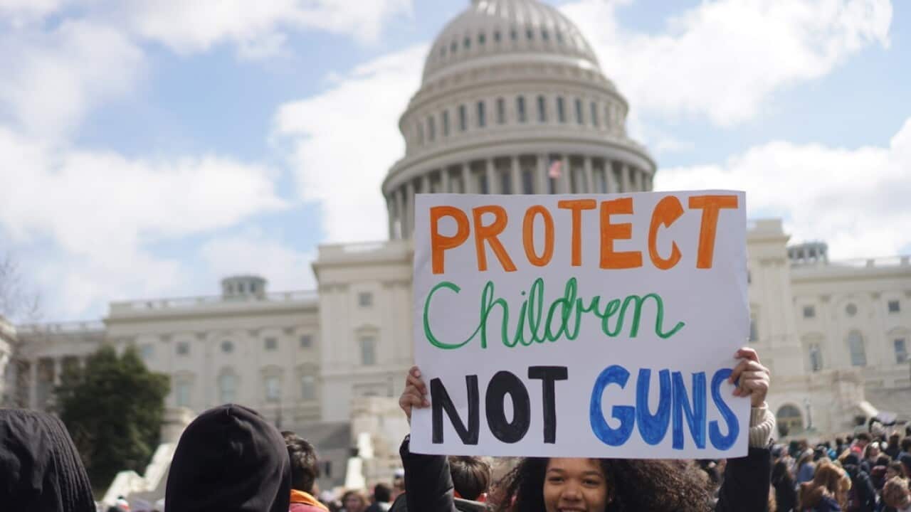 A student holds a sign reading 'Protest children, not guns' in Washington, DC. (AAP)