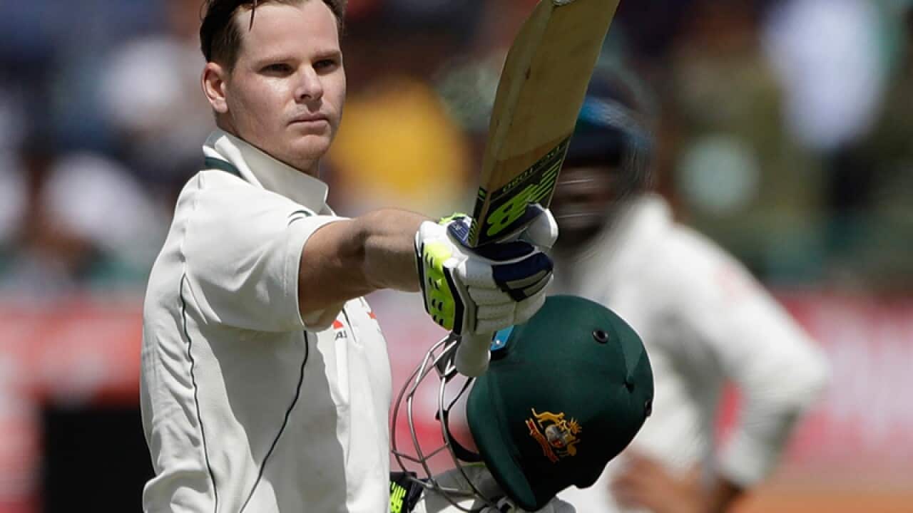 Steven Smith raises his bat after scoring a century