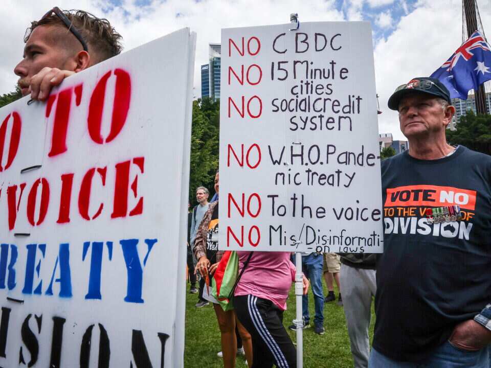 Two men hold posters.