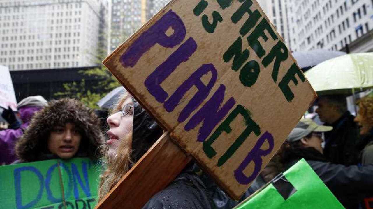 Demonstrators hold signs during a "100 Days of Failure" protest and march in Chicago.