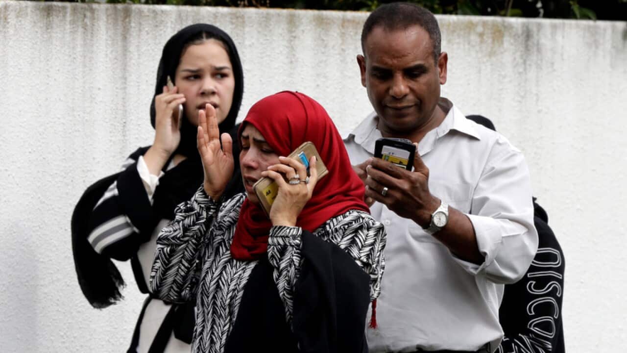 People wait outside a mosque in central Christchurch, New Zealand