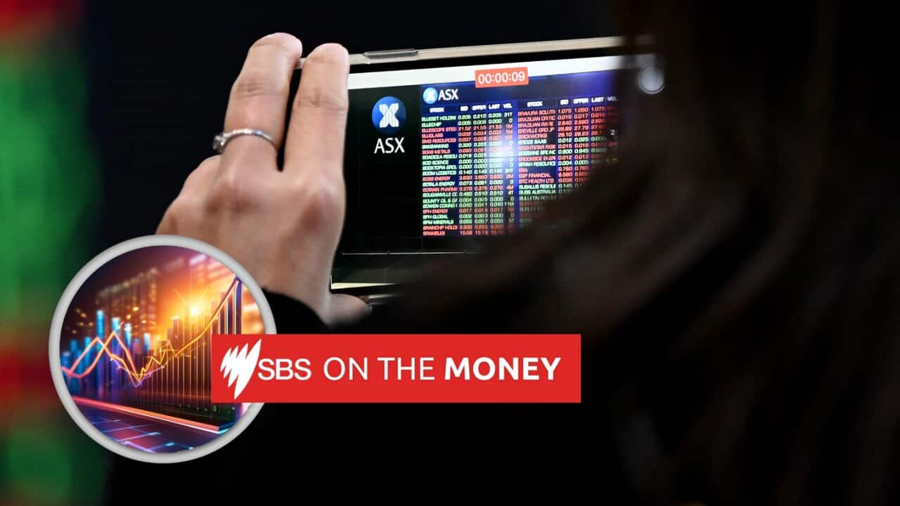 A woman holds a mobile phone showing ASX stock chart