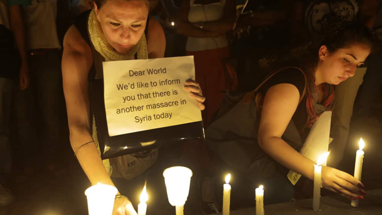 Syrian women light candles during a vigil against a chemical attack