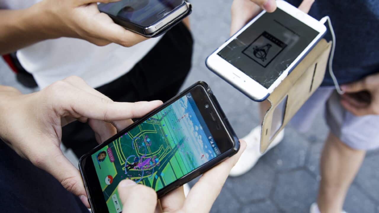 A group of people play the new game 'Pokemon Go'. AAP