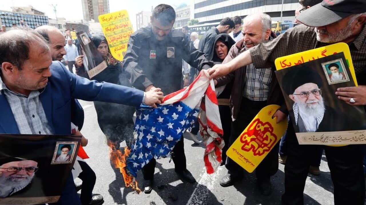 Demonstrators burn a US flag during an anti-US rally