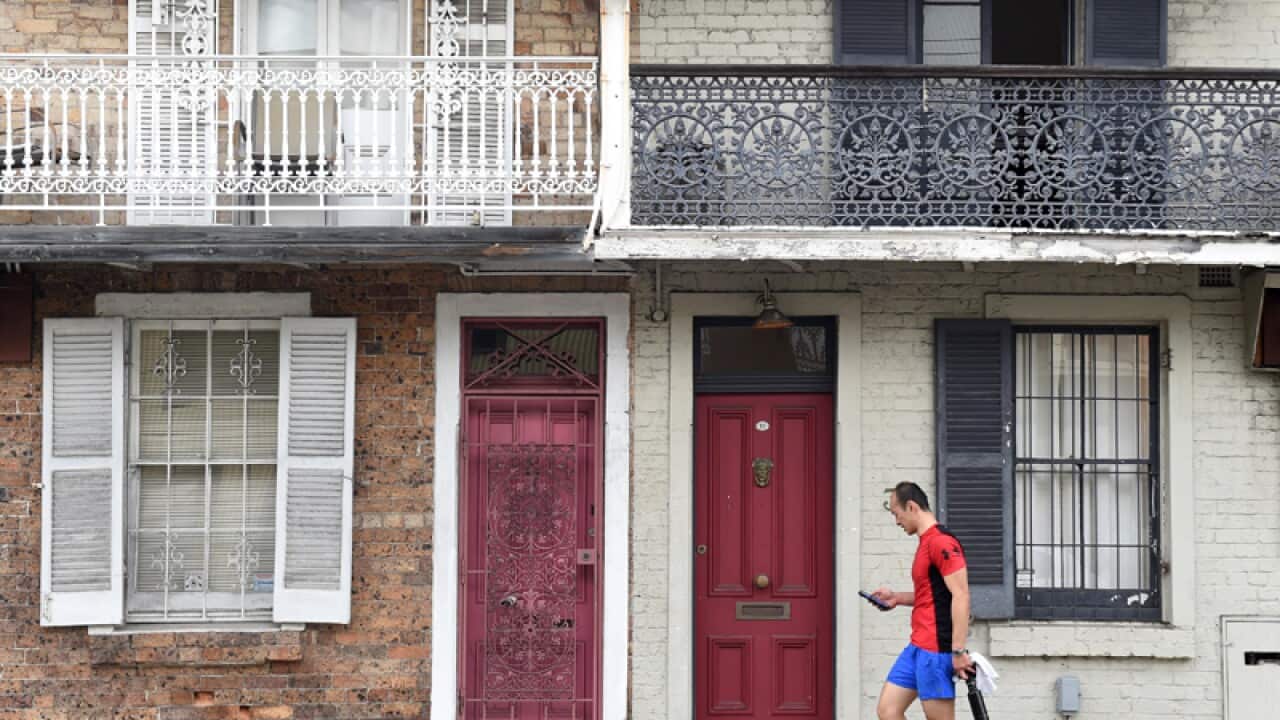 A man walks past residential houses in Sydney