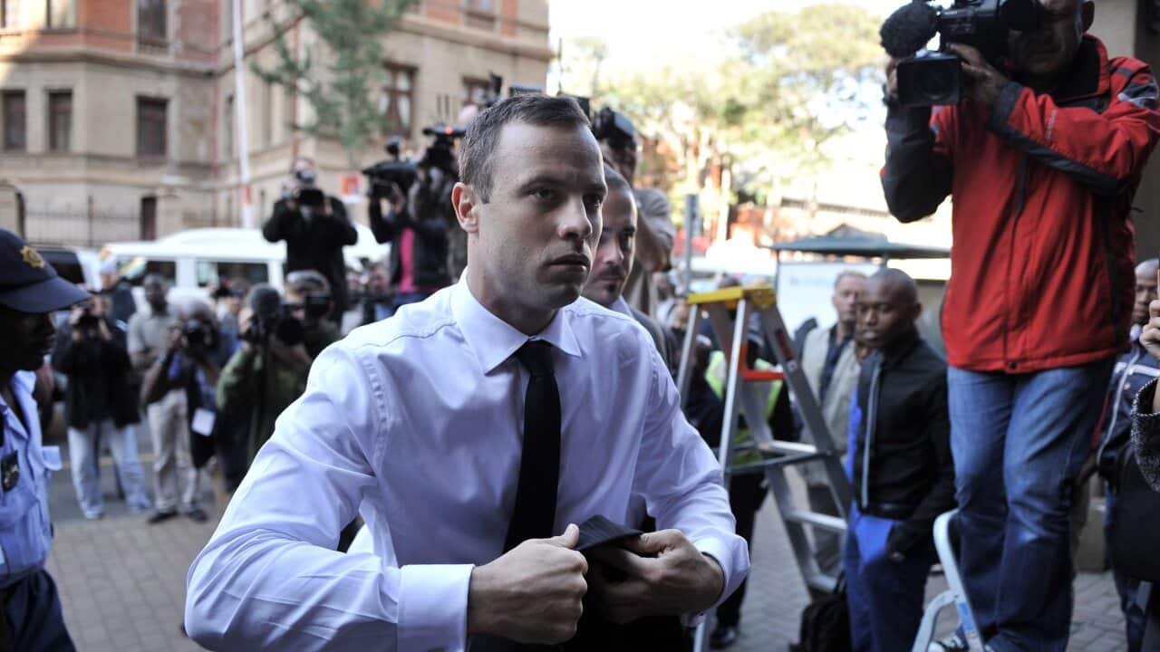 South African Paralympic athlete Oscar Pistorius (C) arrives at court for another day of cross examination in his ongoing murder trial, Pretoria, South Africa (AAP)