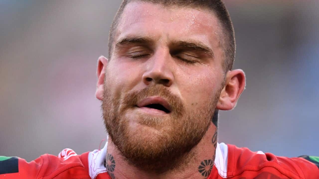 Josh Dugan of the Dragons is assisted from the field