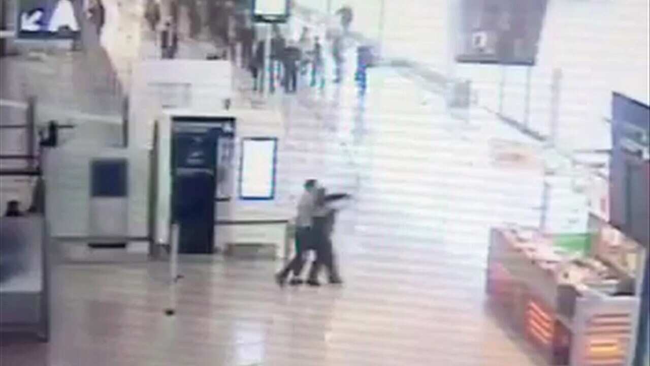 Suspected Islamic extremist Ziyed Ben Belgacem, center left, holds a soldier after grabbing her from behind at Paris Orly airport, Saturday, March 18, 2017.