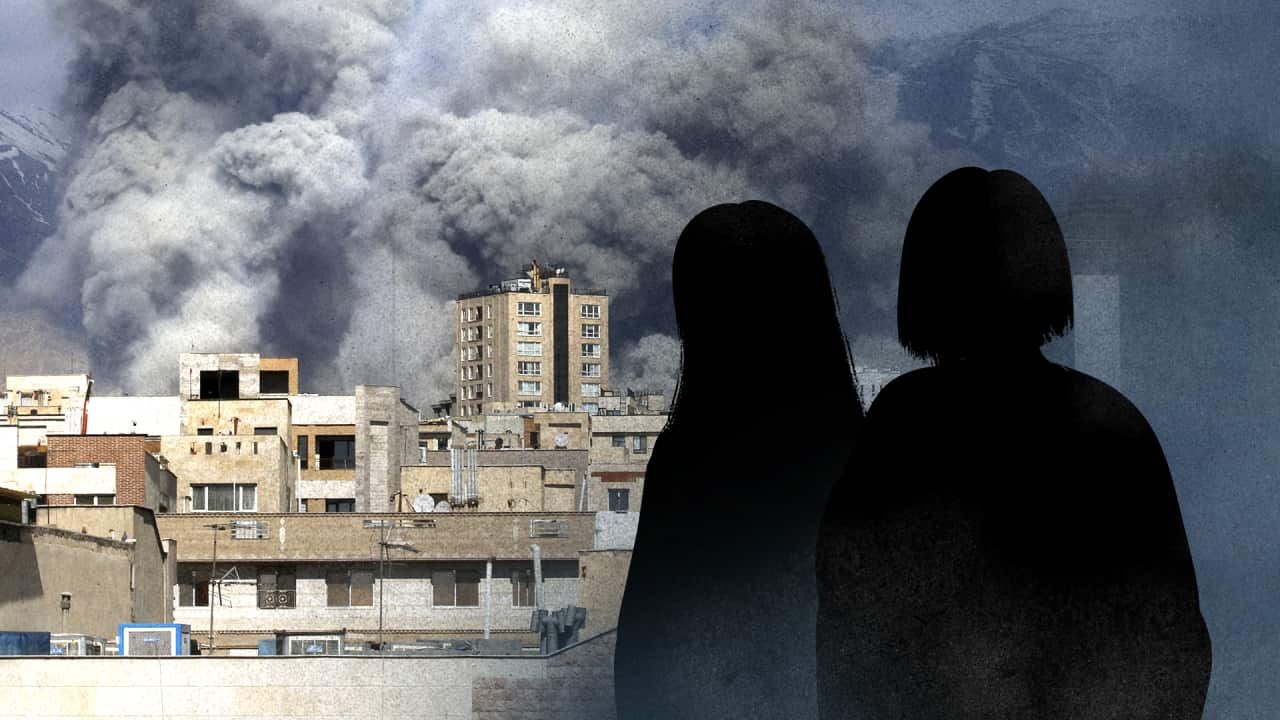 Smoke billows over city buildings in Iran, with two silhouetted figures in the foreground watching the scene.