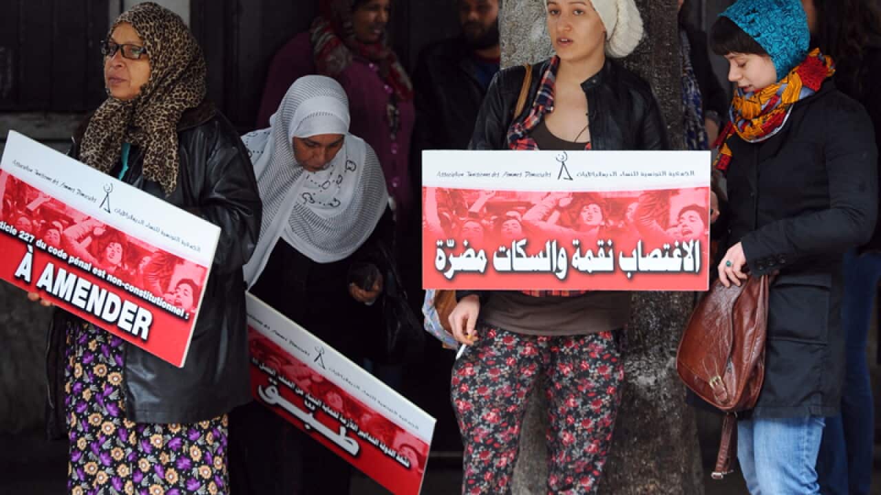 Tunisian protesters hold placards during a demonstration
