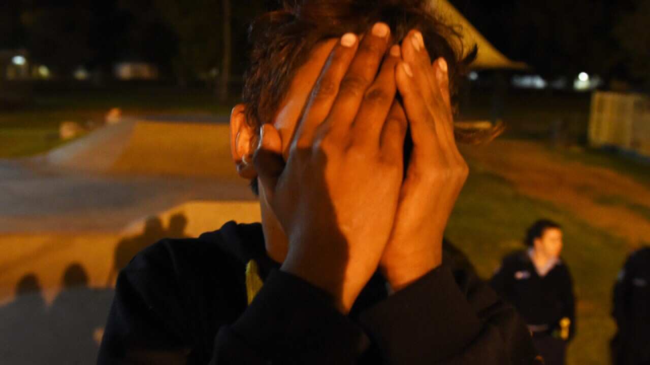 An Aboriginal youth covers his face at a skate park in Bourke, NSW