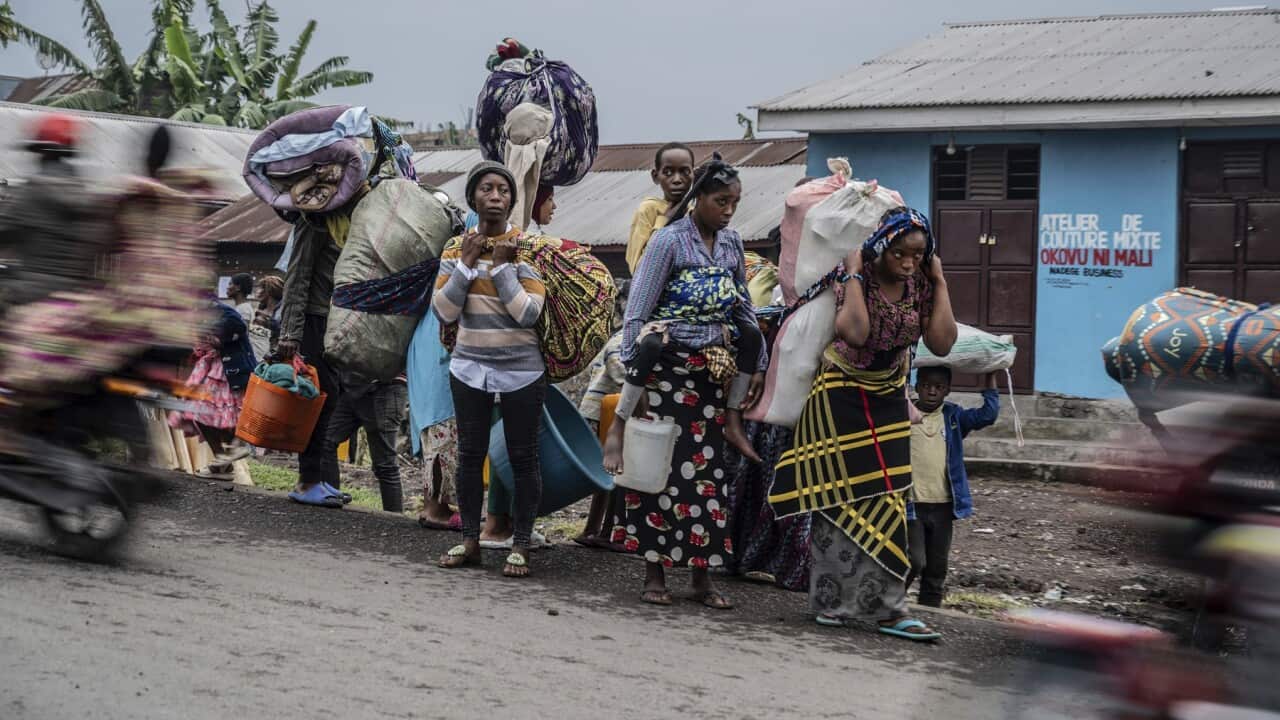 People displaced by the fighting with M23 rebels make their way to the centre of Goma (AAP)