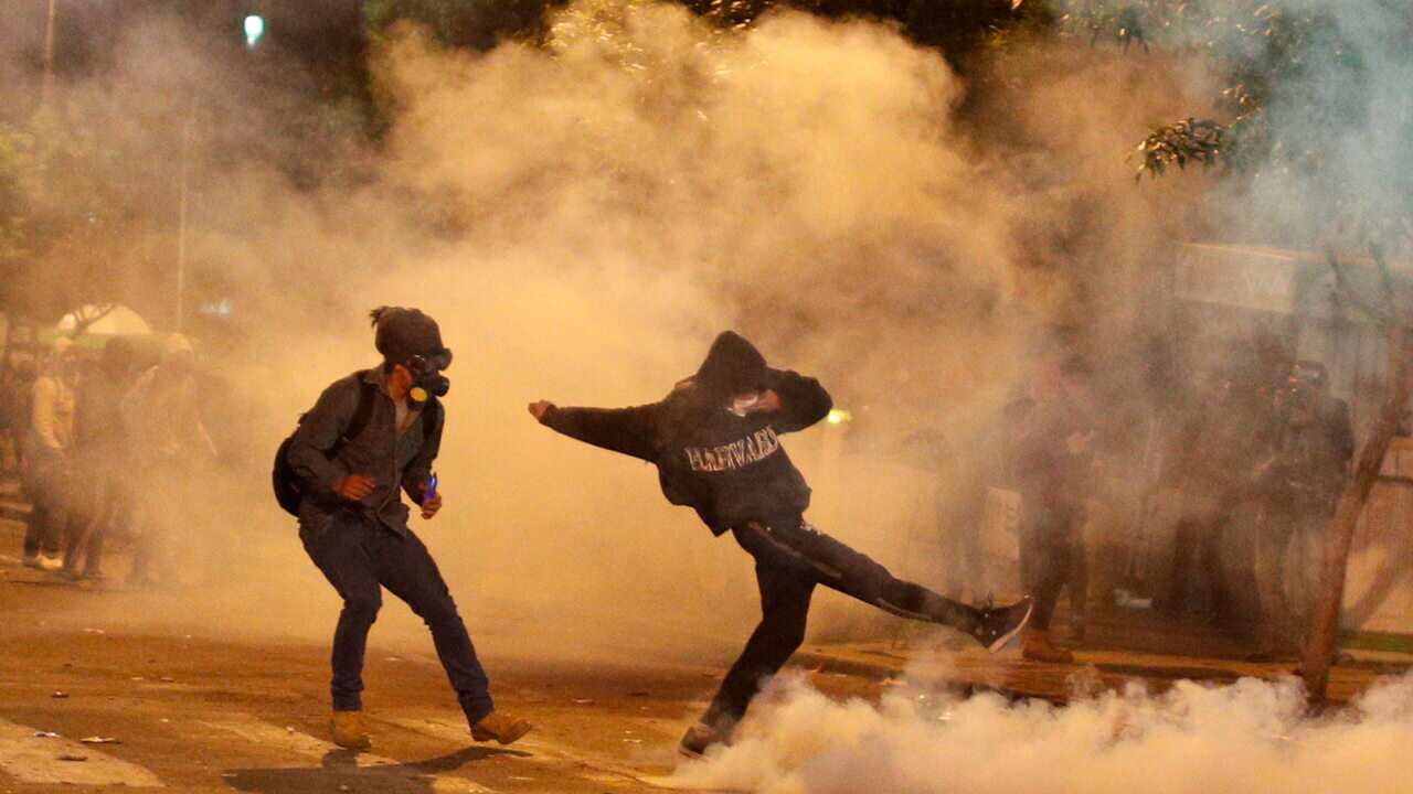 Protesters run away from tear gas fired by the police during an anti-government march against the reelection of President Morales.