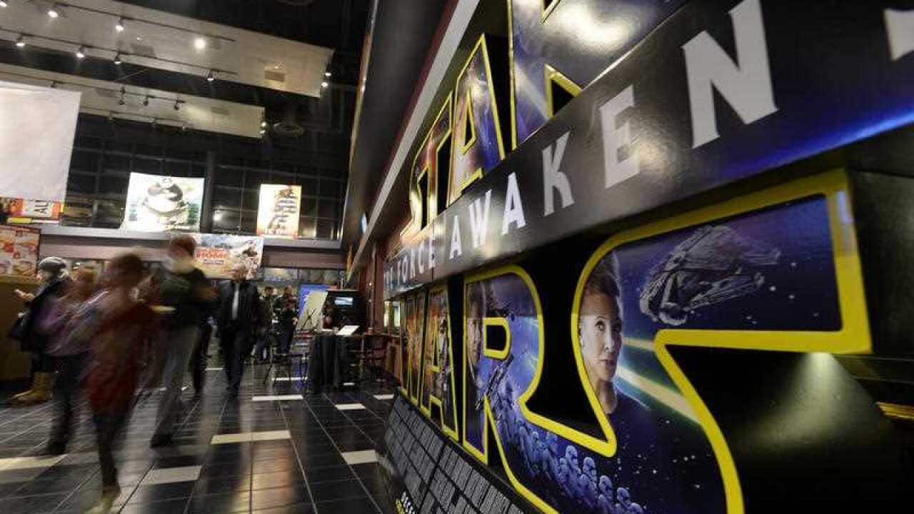 Crowds of people walk into the theatre during opening night of "Star Wars: The Force Awakens".