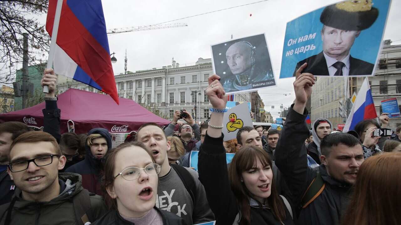Demonstrators carry posters depicting Russian President Vladimir Putin during a massive protest rally in St Petersburg, Russia.