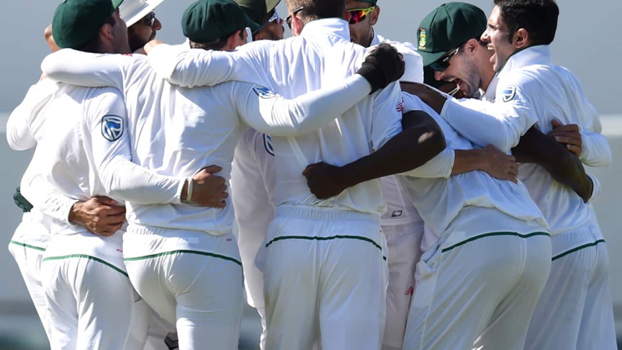 South African cricketers celebrate after winning the first Test