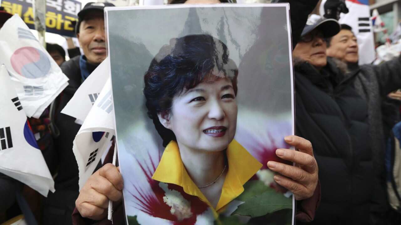A supporter holds a portrait of South Korean President Park Geun-hye