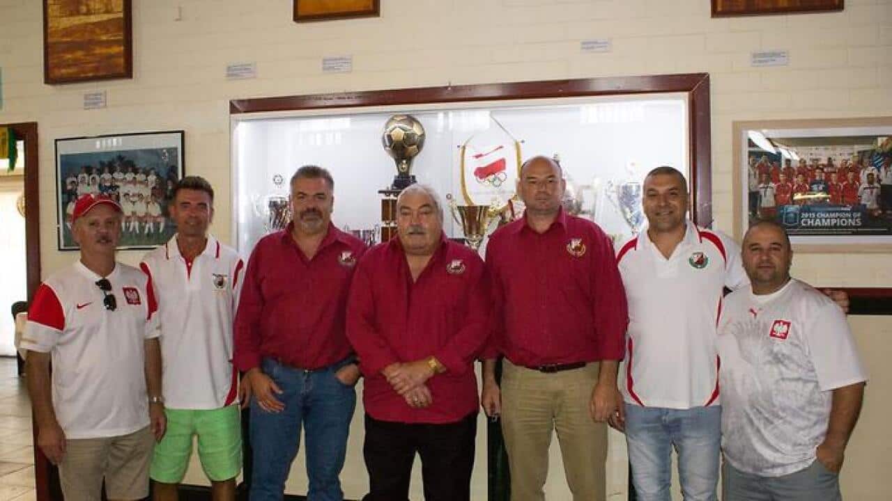 Members of the Polonia sports club in front of their trophy cabinet