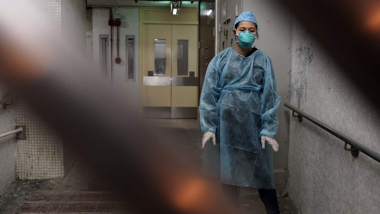 A personnel wearing protective suit waits near an entrance at the Cheung Hong Estate, a public housing estate during evacuation of residents in Hong Kong.