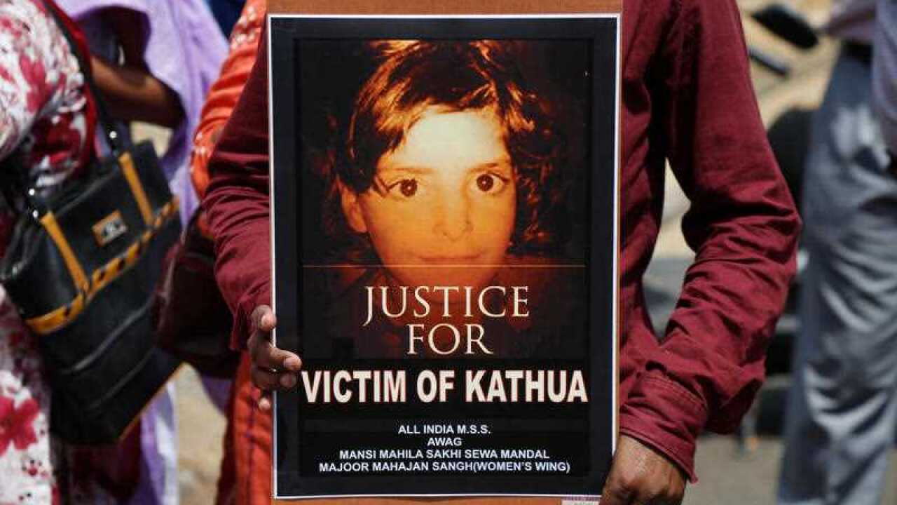 An Indian woman holds a poster with a portrait of Asifa, an 8 year-old girl who was grazing her family's ponies in the forests of the Himalayan foothills when she was kidnapped and her mutilated body found in the woods a week later, in Srinagar, India.