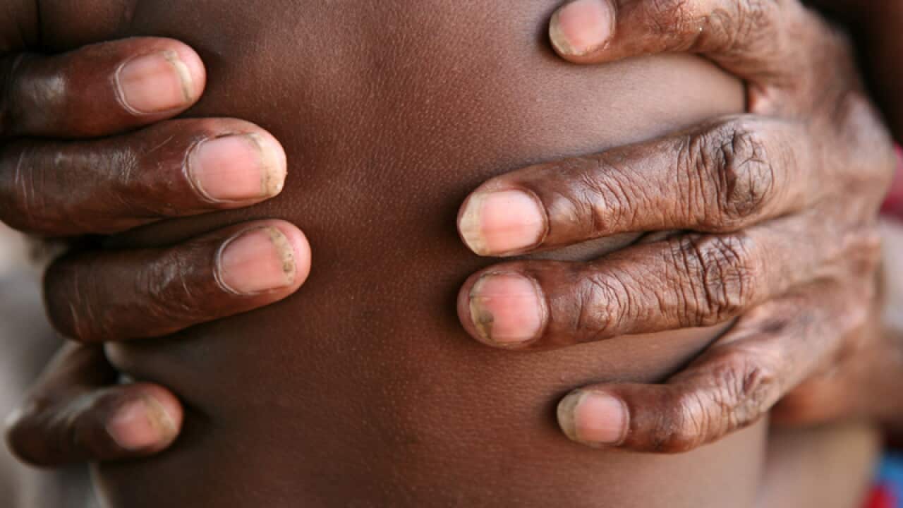A grandmother holds her granddaughter