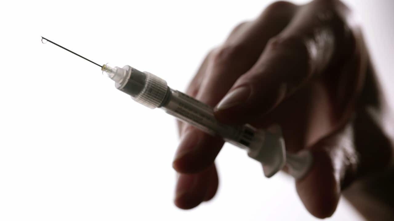 GERMANY, BONN, Symbol image flu vaccination, O,p,s, Hand holds a syringe with a vaccine against flu.