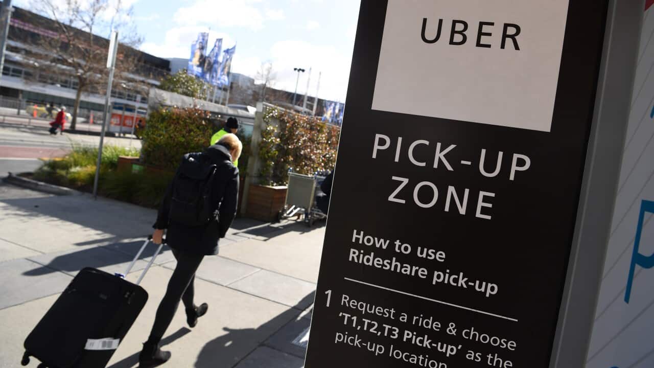 Travellers wait at the designated pick-up zone for Uber at Tullamarine Airport in Melbourne.