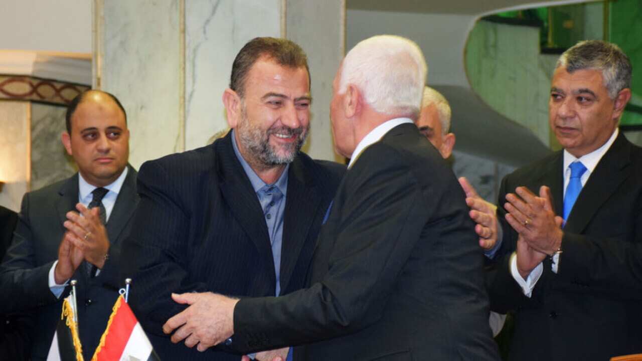 Hamas' Saleh al-Arouri (L) and Azzam al-Ahmad of Fatah shake hands in Cairo on Oct. 12, 2017,