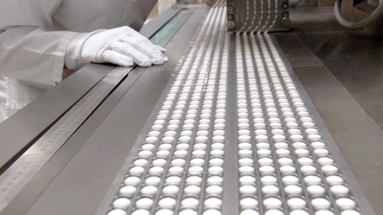 The picture, dated 06 July 2005, shows an employee of the pharma company Bayer checking the production of pills in Bitterfeld, Germany. (EPA/Peter Endig)