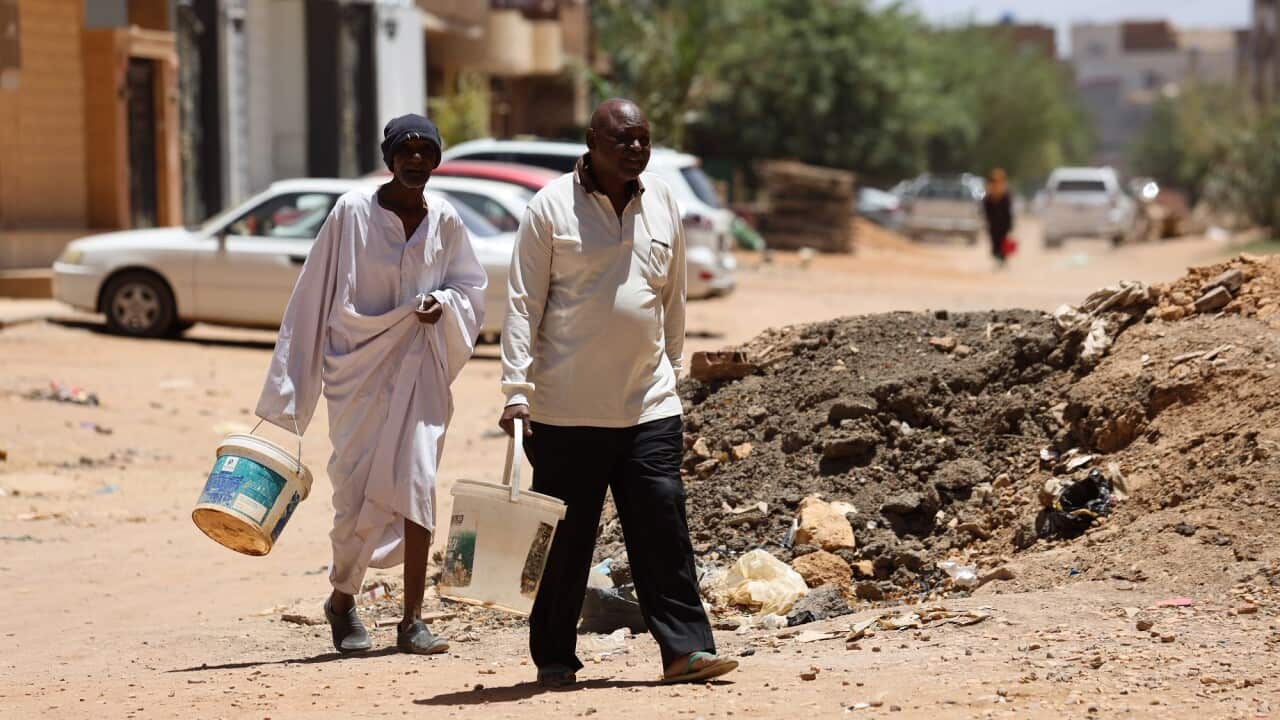 Residents in Sudan carry buckets to transport water amid deadly fighting in Sudan's capital, Khartoum.