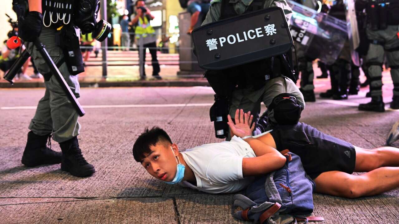 Police officers detain protesters during a rally against a new national security law.
