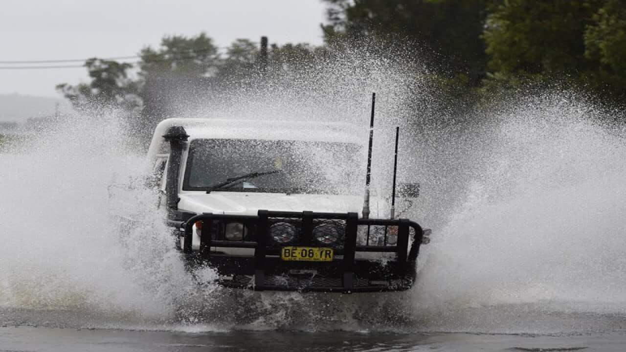 A four wheel drive makes its way through flood waters north of Sydney