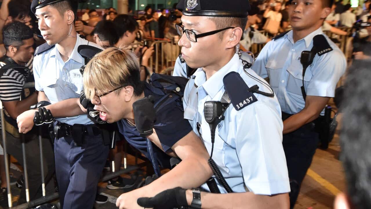 A Hong Kong protester critical of mainland China is evicted by police after demonstrating around the Golden Bauhinia statue