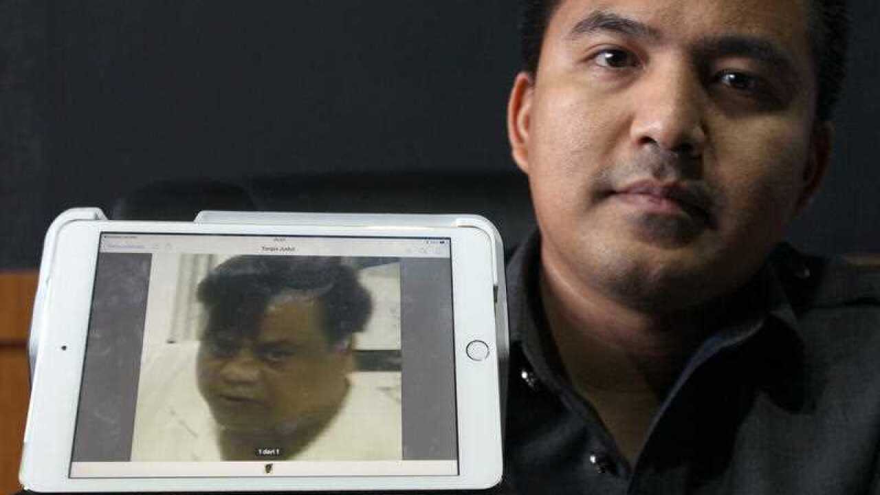 Denpasar Police chief detective Reinhard Habonaran Nainggolan holds a photo of Mohan Kumar alias Rajendra Sadashiv Nikalje is detained in Bali, Indonesia.