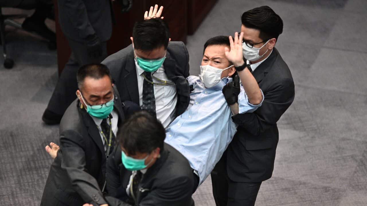 Pro-democracy politician Raymond Chan (C) is carried away by security following scuffles at the Legislative Council in Hong Kong on 8 May.