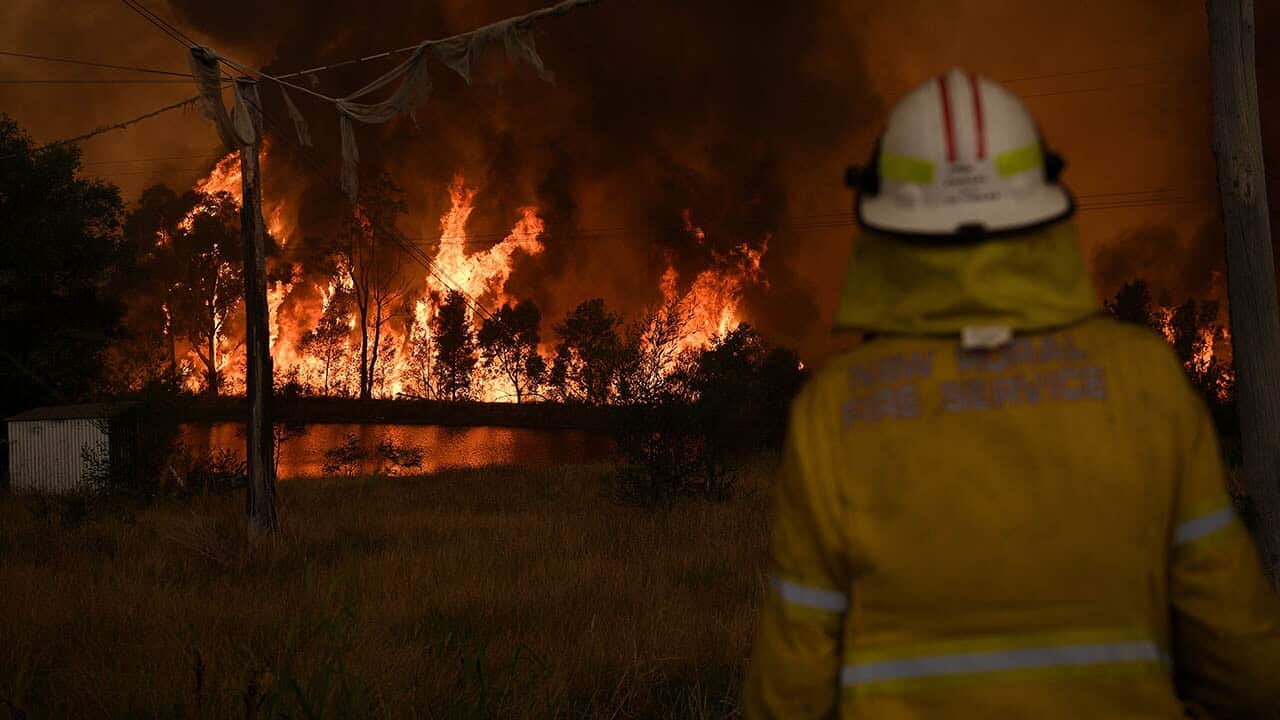 NSW Rural Fire Service crews watch on as on as the Gospers Mountain Fire burns. Firefighters are warning of renewed fire risk.