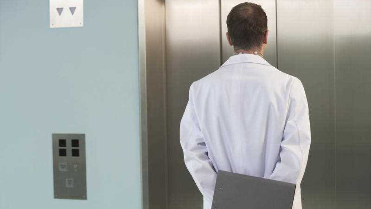 Physician Waiting for the Elevator back view