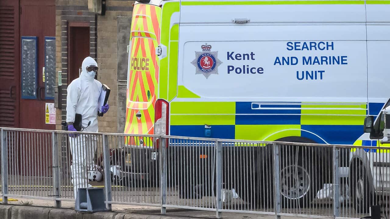 A police officer standing by a police van