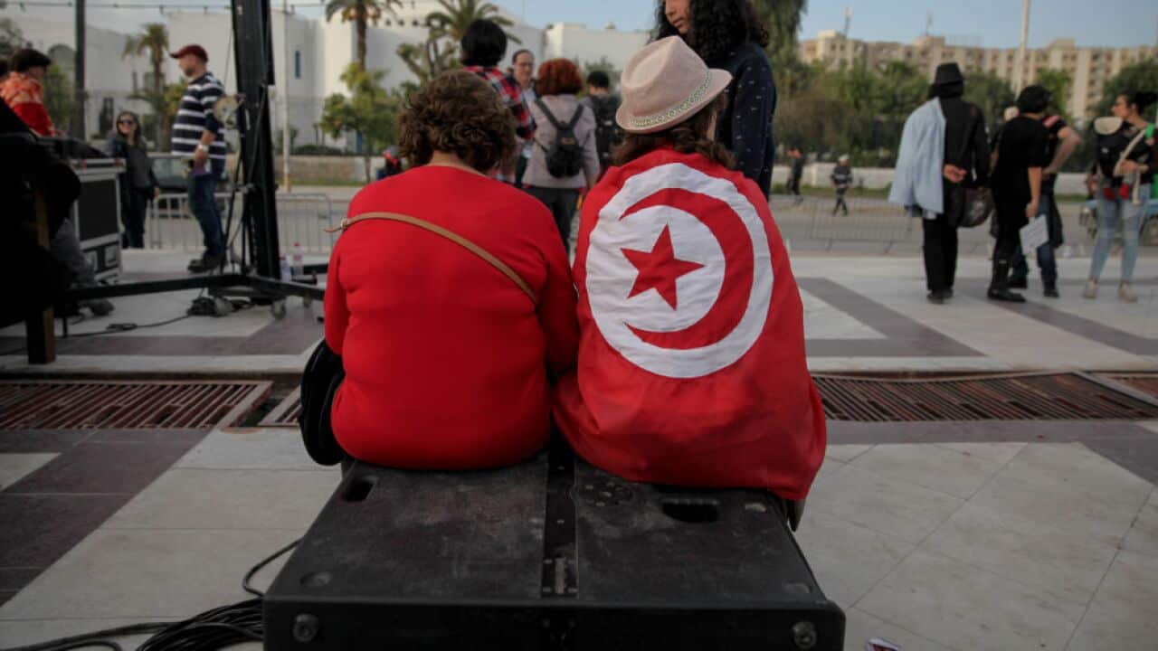 A woman wearing the Tunisian flag is sitting at the end of a march held in Tunis, Tunisia to call for equal inheritance rights and gender equality, on March 10, 2018.