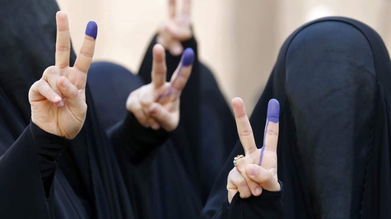 Fully-veiled Iraqi women flash the victory sign