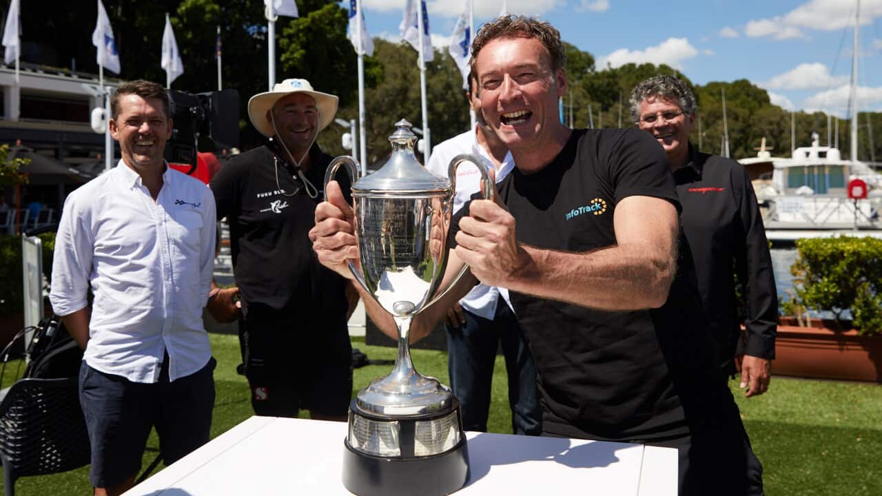 Christian Beck of Infotrack poses with the Sydney to Hobart yacht race trophy during a Sydney to Hobart yacht race briefing in Sydney.