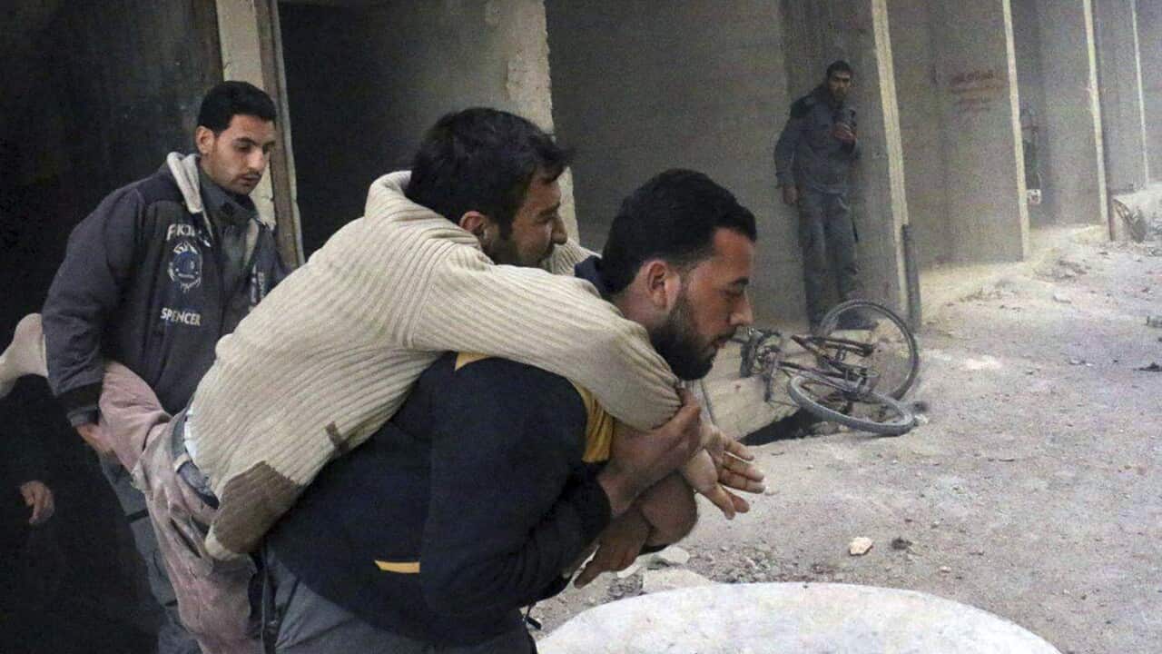 A member of the Syrian Civil Defense group carrying a man who was wounded after airstrikes and shelling hit in Ghouta, Syria.