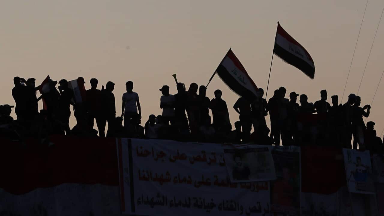 Anti-government protesters gather stand on a building near Tahrir Square during ongoing protests in Baghdad, Iraq, Saturday, Nov. 2, 2019. (AP Photo/Khalid Mohammed)