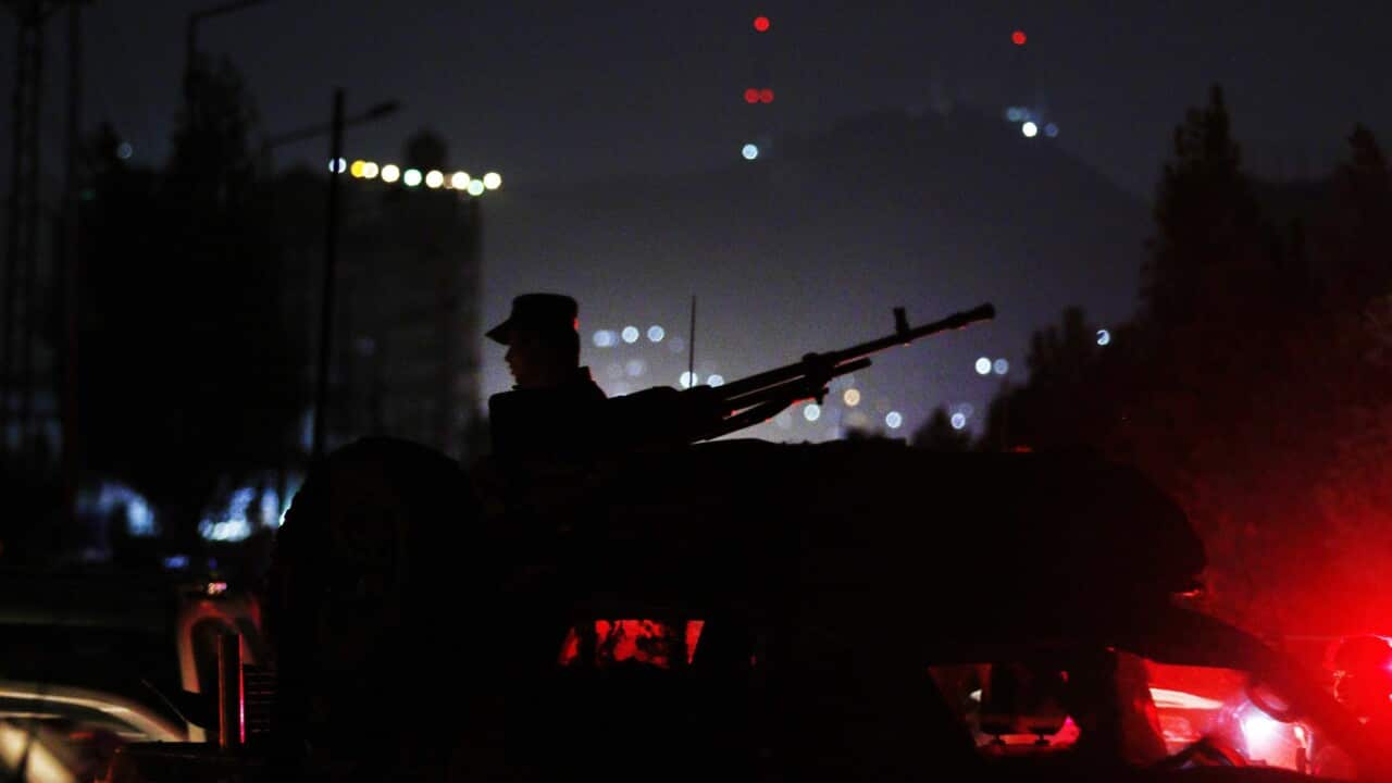Afghan security officials secure the road leading to the American University of Afghanistan after a Taliban attack on the University in Kabul,