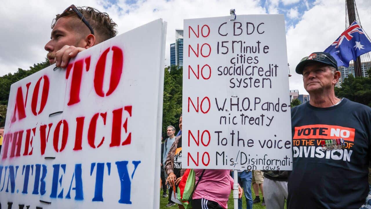 Two men hold posters.