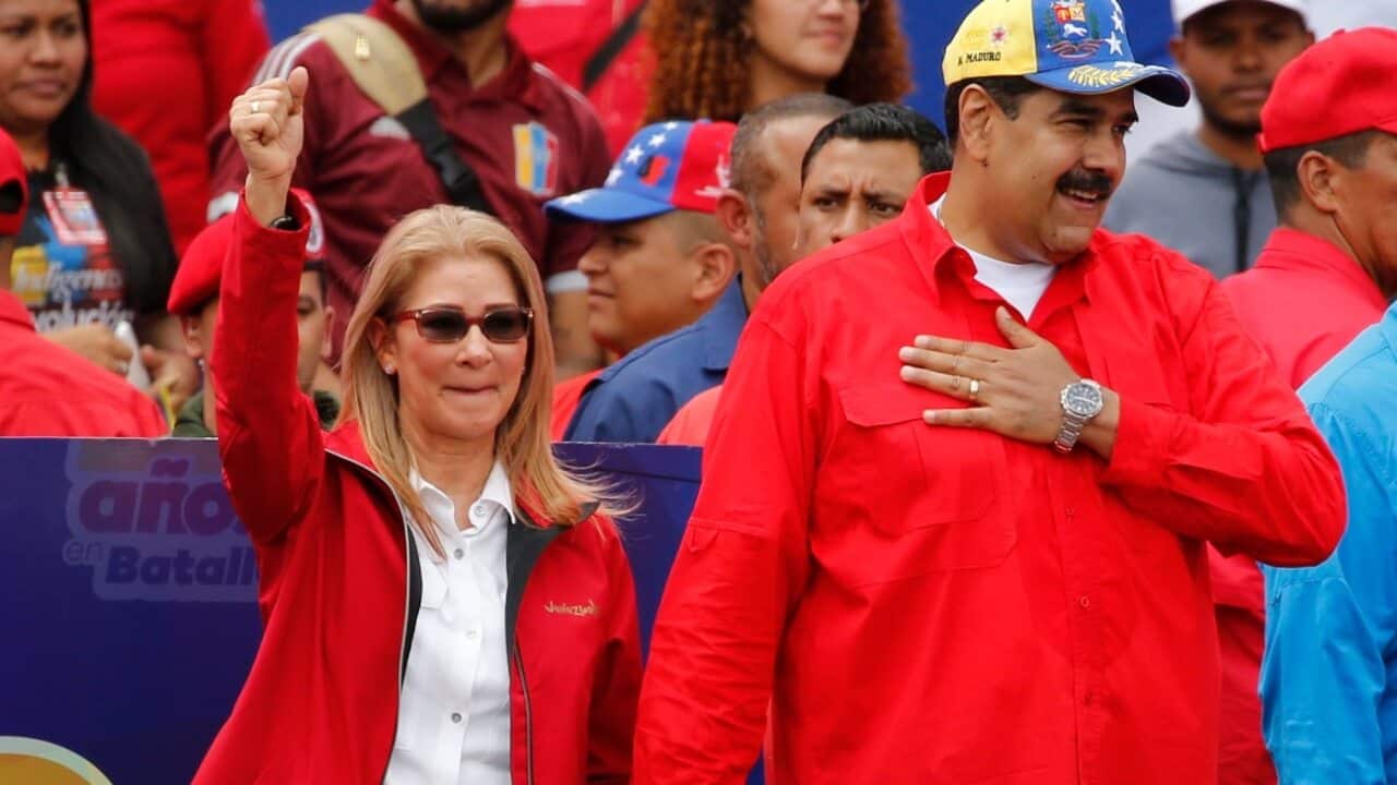 Venezuela's President Nicolas Maduro and first lady Cilia Flores acknowledge supporters at the end of a rally in Caracas, Venezuela.