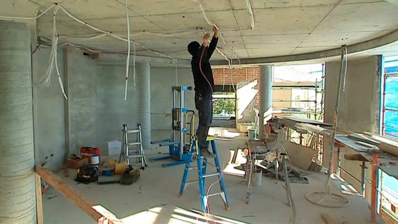 A migrant worker installing electrical circuits