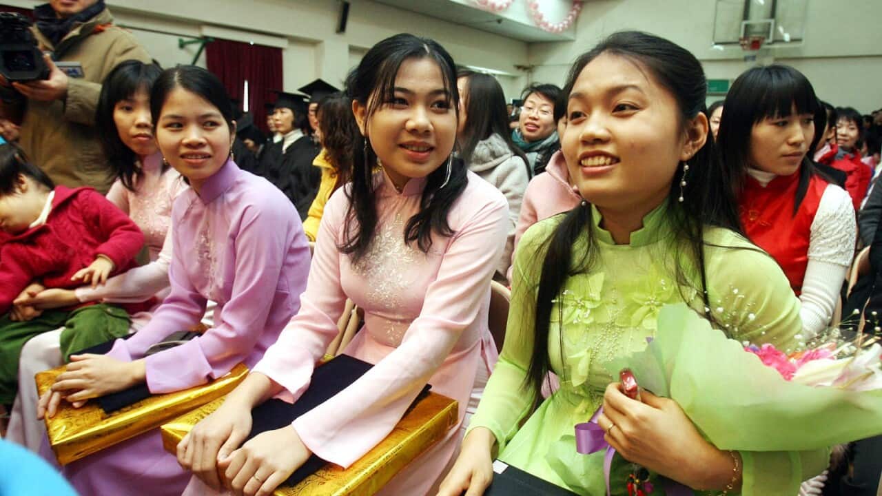 Migrant wives (front row) dressed in their home country's traditional costumes, smile after graduating from a Korean-language (AAP Image/Yonhap News Agency) NO ARCHIVING, AUSTRALIA ONLY
